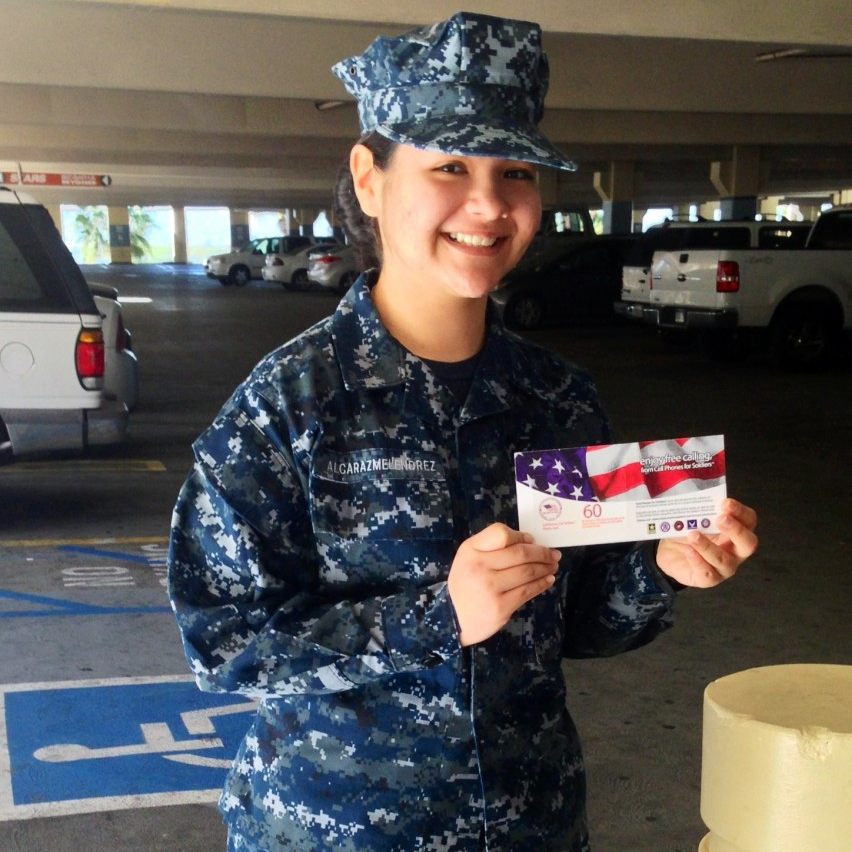 Female service member holding 100 millionth calling card.