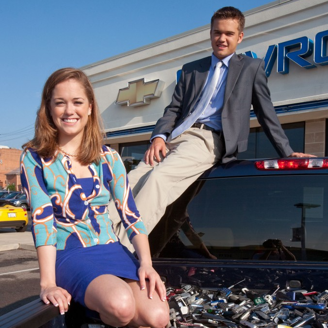 Brittany and Robbie, founders of Cell Phones for Soldiers, posing with a pickup truck filled with donated mobile phones.