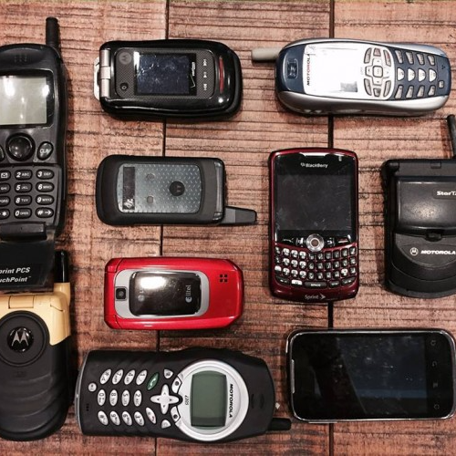 Various types of cell phones displayed on a table.