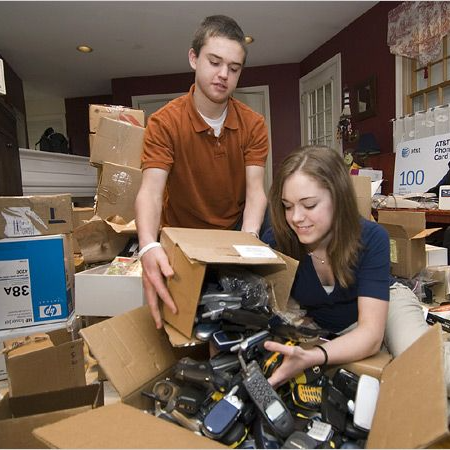Robbie and Brittany Bergquist sorting donated phones after Cell Phones For Soldiers is featured on CBS Evening News, June 2007.