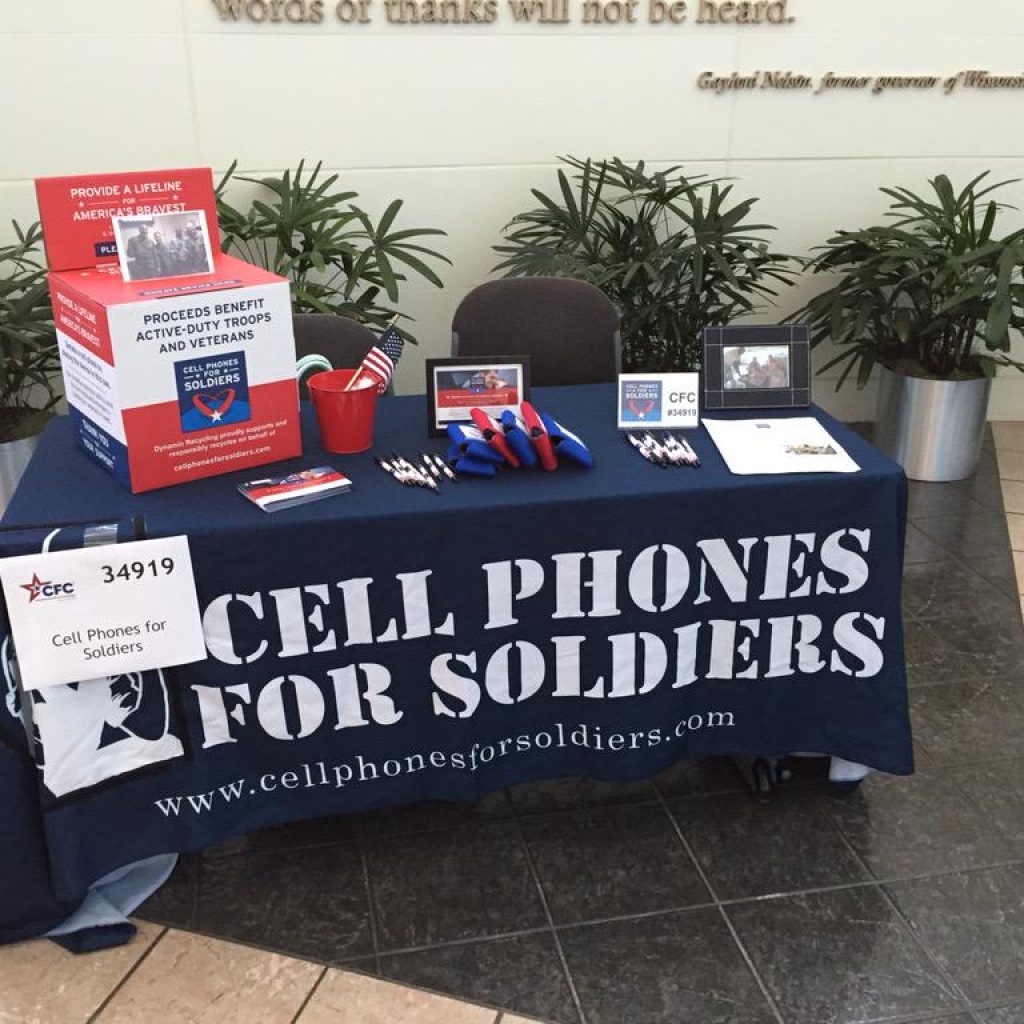 resources Cell Phones For Soldiers volunteer table with donation materials and promotional items.